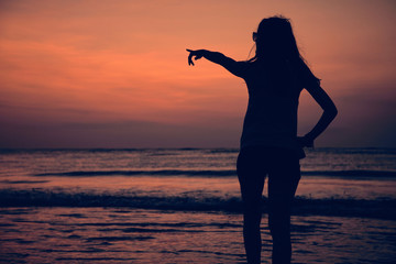 Silhouette of a girl in sunset / sunrise time over the ocean.