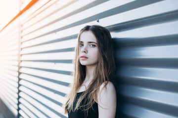 Cute cheerful portrait of young teenage girl outdoors in the street . Emotions, portrait, beauty concept