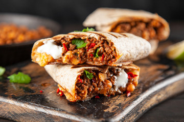 Mexican burrito with beef, beans and sour cream - obrazy, fototapety, plakaty