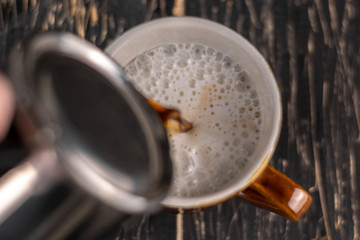 Closeup image of male hands pouring coffee and milk artist and preparation concept, morning coffee.