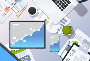 Fototapeta premium analysis financial graph finance business chart growth concept top angle view desktop laptop smartphone tablet screen paper report office stuff horizontal