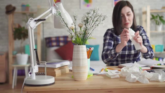 Severe allergic reaction to the flowers,a young woman sneeze into disposable handkerchiefs