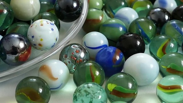 colored glass balls on white background, glass marbles for children,