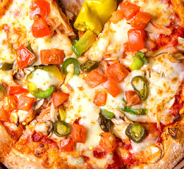 Tasty Italian pizza Mexicano in a box on brown concrete background. Top view of hot pizza with jalapeno pepper , a very hot green chili pepper, used especially in Mexican-style cooking. Flat lay
