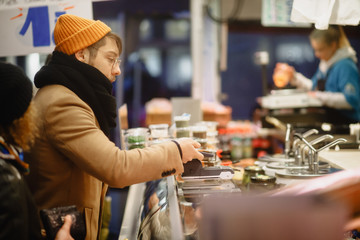 Contactless payment. A man pays with a phone on the market. Checkout Counter Customer Pays with Smartphone for His Items. Modern Wireless Paying Terminal System