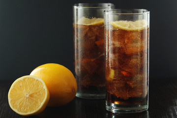 Glasses with cuba libre cocktail or cola with ice or cold tea with lemon
