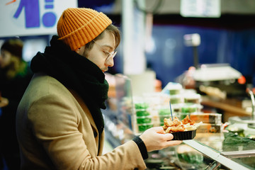 Contactless payment. A man pays with a phone on the market. Checkout Counter Customer Pays with Smartphone for His Items. Modern Wireless Paying Terminal System