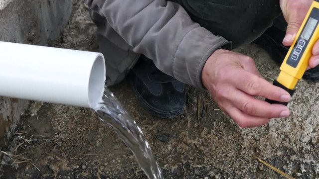 a man measuring the value of drinking water hardness with tds meter,