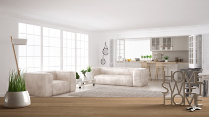 Wooden table, desk or shelf with potted grass plant, house keys and 3D letters home sweet home, over scandinavian living room with kitchen, architecture interior design background
