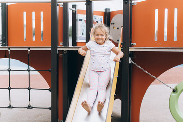 Happy positive girl playing in kindergarten, laughing and smiling. Childhood, active life, sport concept