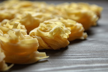 Tagliatelle italian pasta on brown wooden table