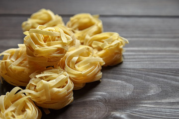 Tagliatelle italian pasta on brown wooden table