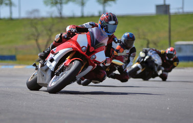 Road racing motorcykel in high speed into a curve, panning shot