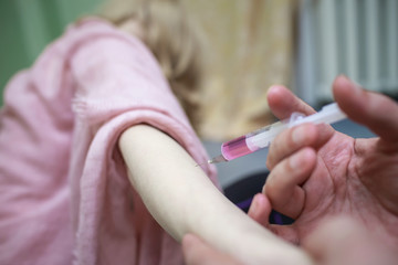 A man forcibly injects a medicine or narcotic drug to a young girl, a woman with a syringe and needle.