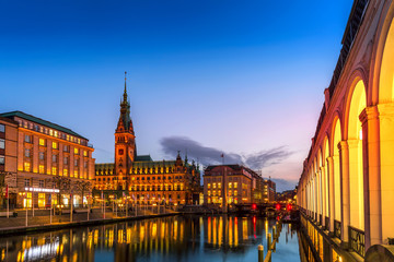 View of Hamburg townhall Rathaus and small Alster lake during twilight sunset.