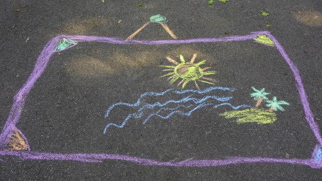 Young kid chalk drawing of sea water, tropical island with palms and sun on pavement of sidewalk outdoors at city park. Child drawing of summer sunny beach. Real time 4 k video footage.