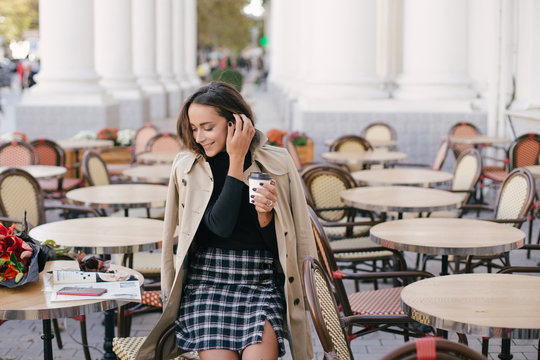 Young beautiful woman drinking coffee in a street cafe