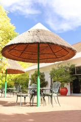 Tables with chairs under sun umbrellas - place to sit and relax in a holiday resort