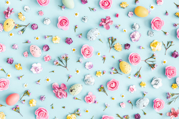 Easter eggs, colorful flowers on pastel blue background. Easter, spring concept. Flat lay, top view