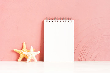 Blank white notepad and starfishes on the wooden table