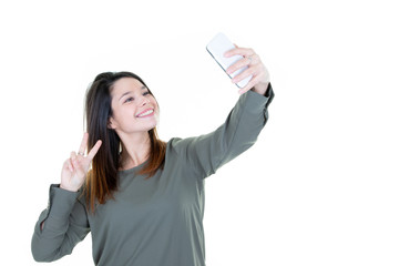 Fashion cool girl taking picture selfie portrait on smartphone making peace sign over white background