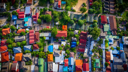 Fototapeta na wymiar Aerial view of the village in Thailand, Samui island. colored roofs, green trees, sunny weather. 