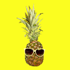 Funny Pineapple fruit in sunglasses on bright yellow background. Summer holidays and party theme