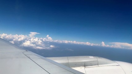 wing of airplane flying above the clouds