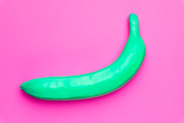 Minimal painted green Banana fruit on colored pink pastel background. Creative concept.