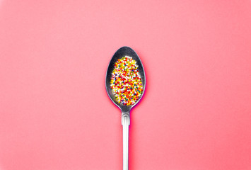 Creative summer vitamin minimal background with a spoon and candy sweets. Flat lay concept in bright pastel colors