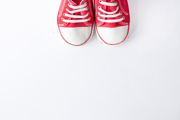 Cute red small sized canvas shoes top view on white background with copyspace