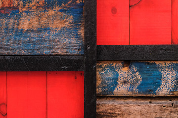 Derevyanny old textural painted colorful background. Red and shabby blue, separated by a black board.