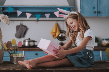 Happy girl looking with pleasure on present box