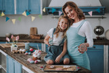 Little girl with mom showing egg shaped cookies