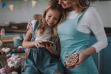 Little girl with mom looking at egg shaped cookies