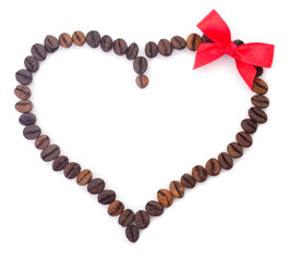 Coffee beans in the shape of a heart with a bow.