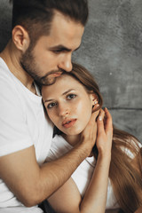 Young romantic couple is kissing and enjoying the company of each other at home