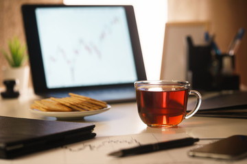An image of a morning, office desk of a financial analyst close-up.