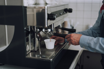 Man making fresh coffee with professional coffee machine