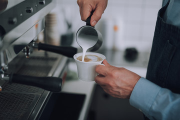 Fototapeta na wymiar Man in apron making delicious latte art in cafe