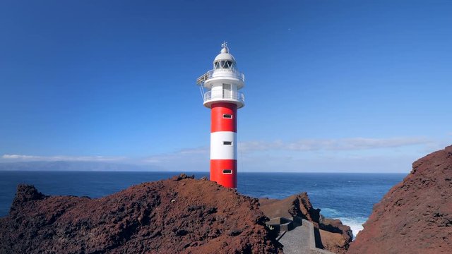 View of the famous lighthouse of Teno in the Isle of Tenerife. La Gomera island is in the background