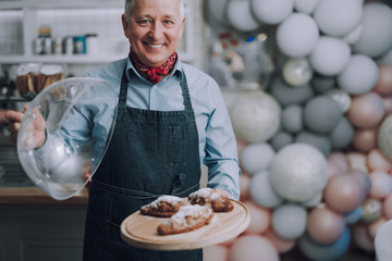 Joyful bakery shop owner demonstrating delicious pastries