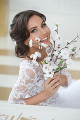 Happy laughing bride with a bouquet of cherry blossoms in her hands.