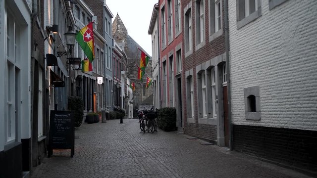 Dutch Carnival flags flying in Maastricht, empty cobbled street, Netherlands, 4k footage, vastenavond carnaval