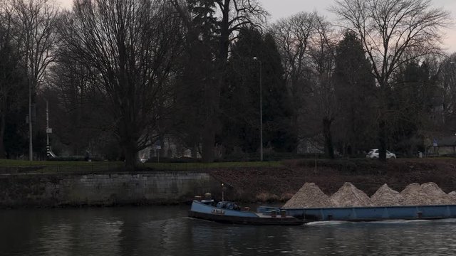 Long boat or Barge carrying materials on the Maas river in Maastricht, Netherlands, Canal Boat transporting goods