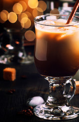Summer cold coffee with ice and milk, brown kitchen table, close up selective focus