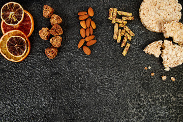 Obraz na płótnie Canvas Healthy snacks - variety oat granola bar, rice crips, almond, dried orange