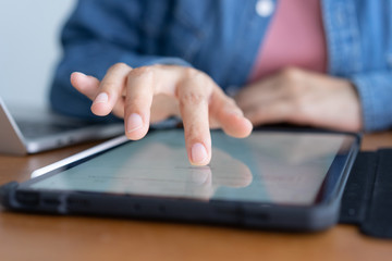  Closeup hand of asian women are using tablet on wood table