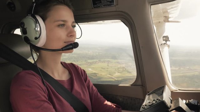 Young confident woman piloting a small civilian plane