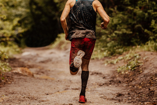 Back Dirty Man Runner In Compression Socks Running On Spring Trail